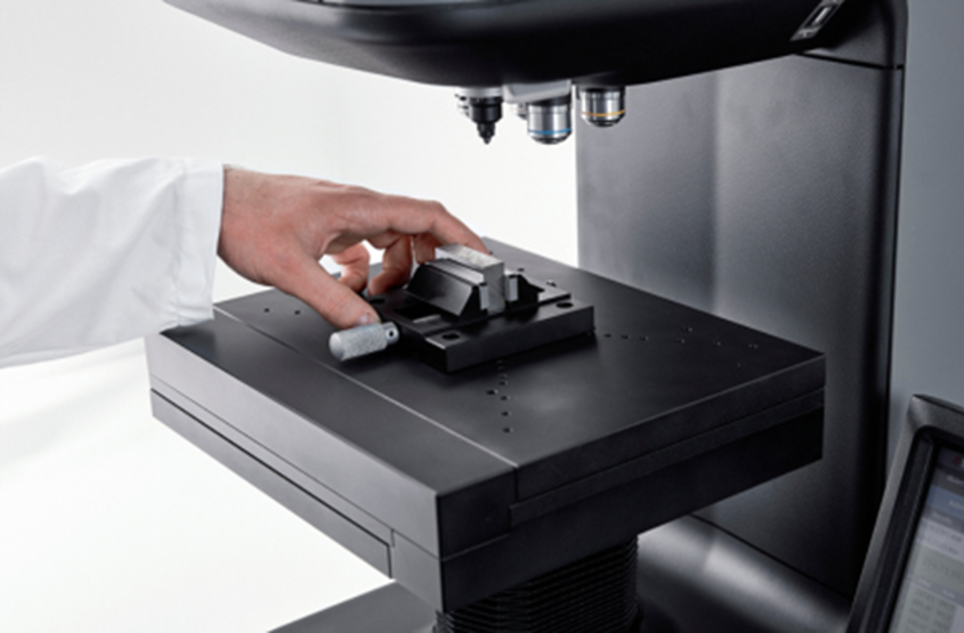 Operator placing a specimen on a Struers hardness tester stage